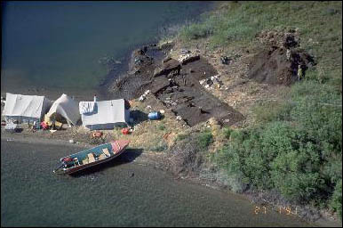 Vue aérienne d'un site d'excavation archéologique sur le bord de l'eau.