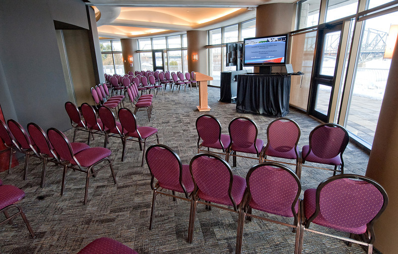 A room with rows of purple chairs and a tv.