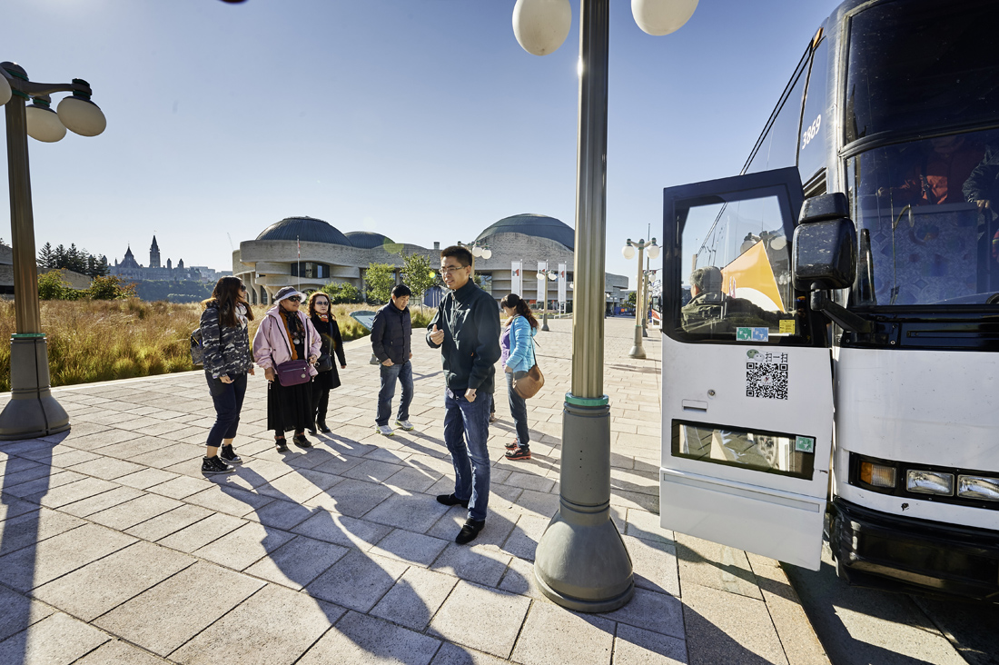 Un groupe de personnes montant à bord d'un autobus à Ottawa, prêts à visiter le Musée canadien de l'histoire.