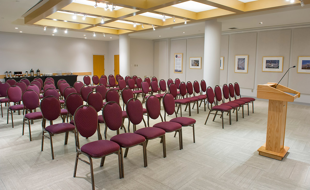 Une salle avec des rangées de chaises et un podium située à Ottawa au Musée canadien de l'histoire.