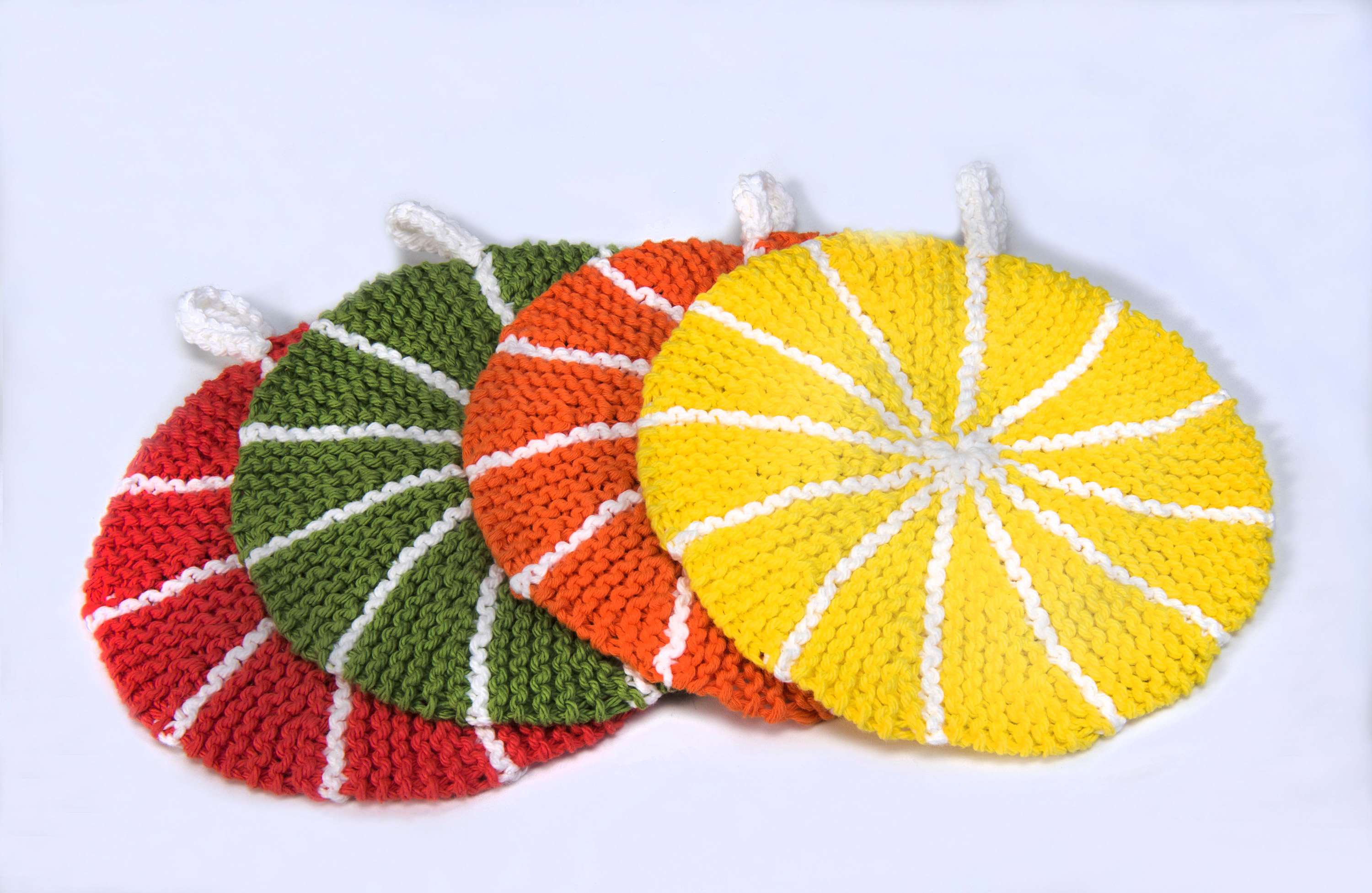 Un ensemble de maniques de fruits au crochet sur une surface blanche à Ottawa.