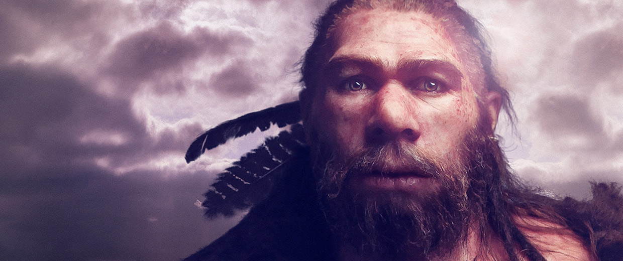 A bearded man in Ottawa, standing in front of the Canadian Museum of History, with feathers in front of a cloudy sky.