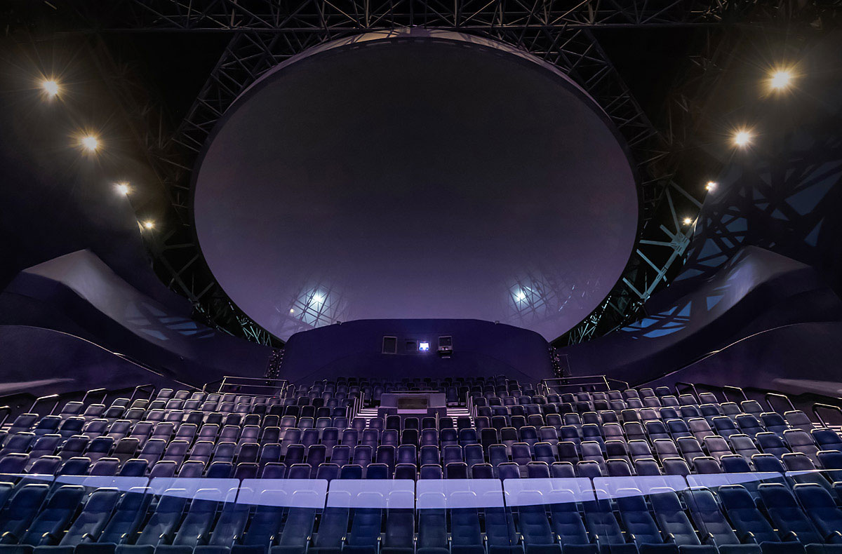 Une salle de location avec des chaises bleues et un grand dôme.