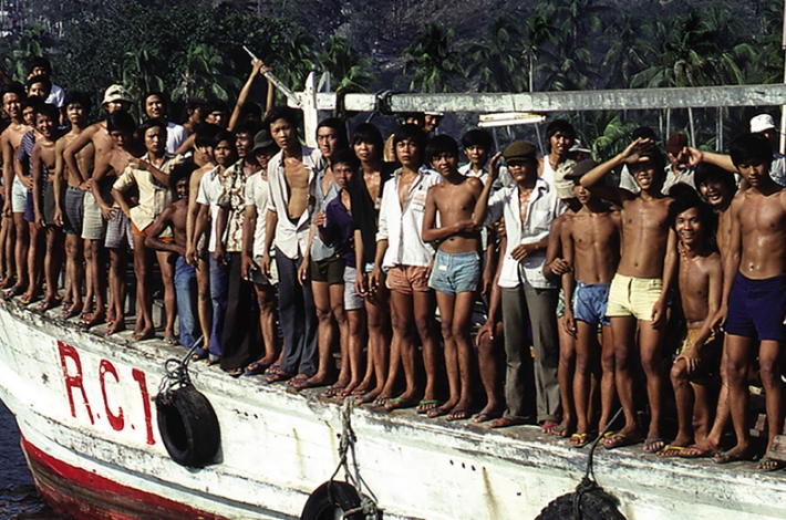 Un groupe d'hommes profitant de la liberté à l'arrière d'un bateau.