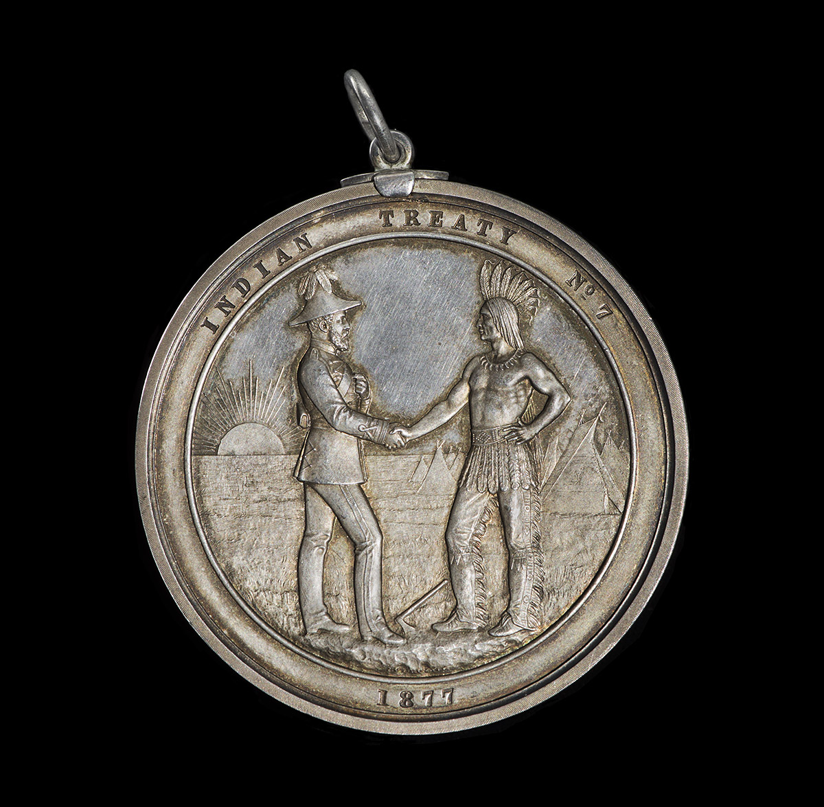 Une médaille d'argent avec deux hommes se serrant la main au Musée canadien de l'histoire à Ottawa.