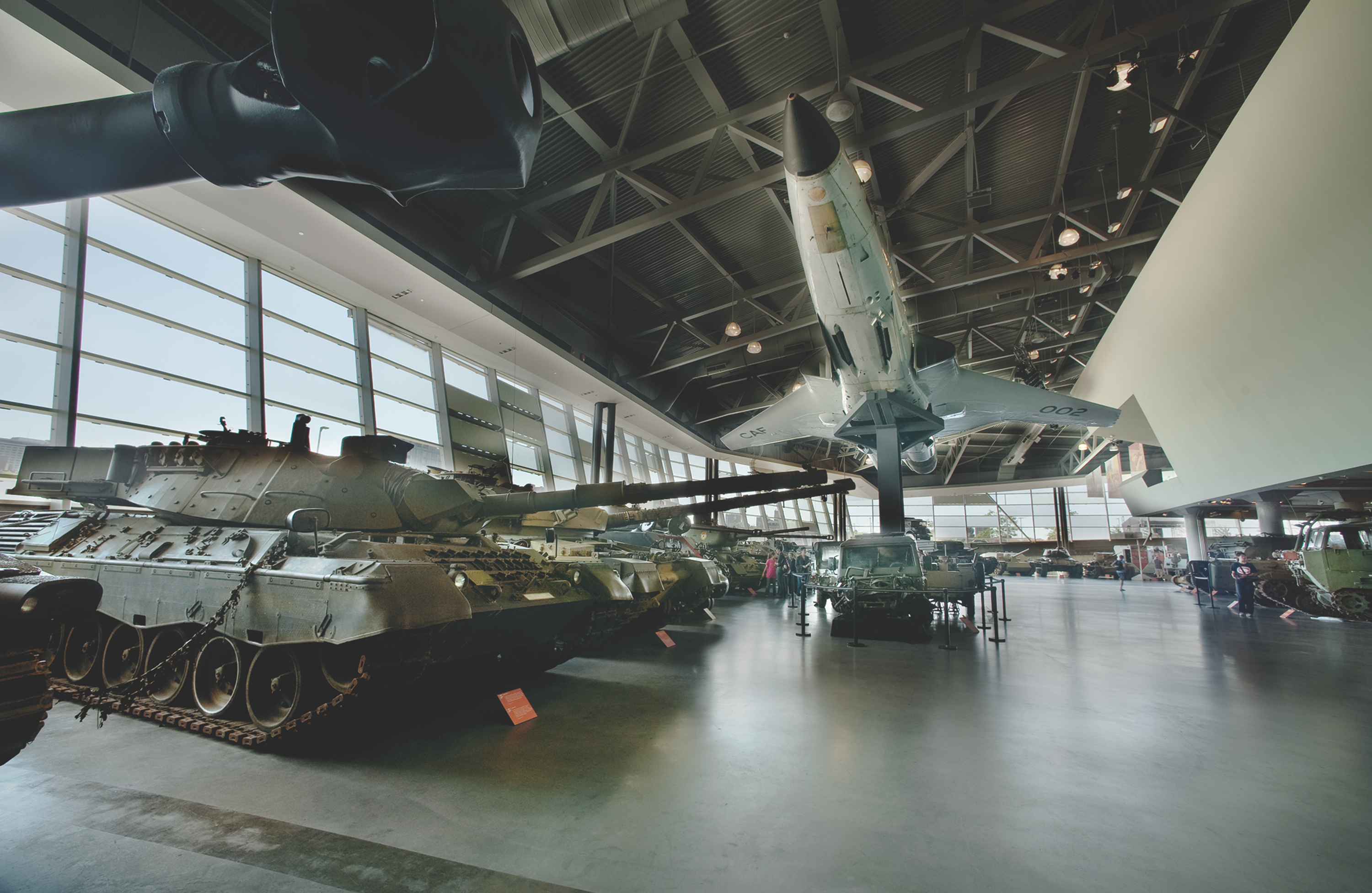 Warplane and tank on display in a museum showroom