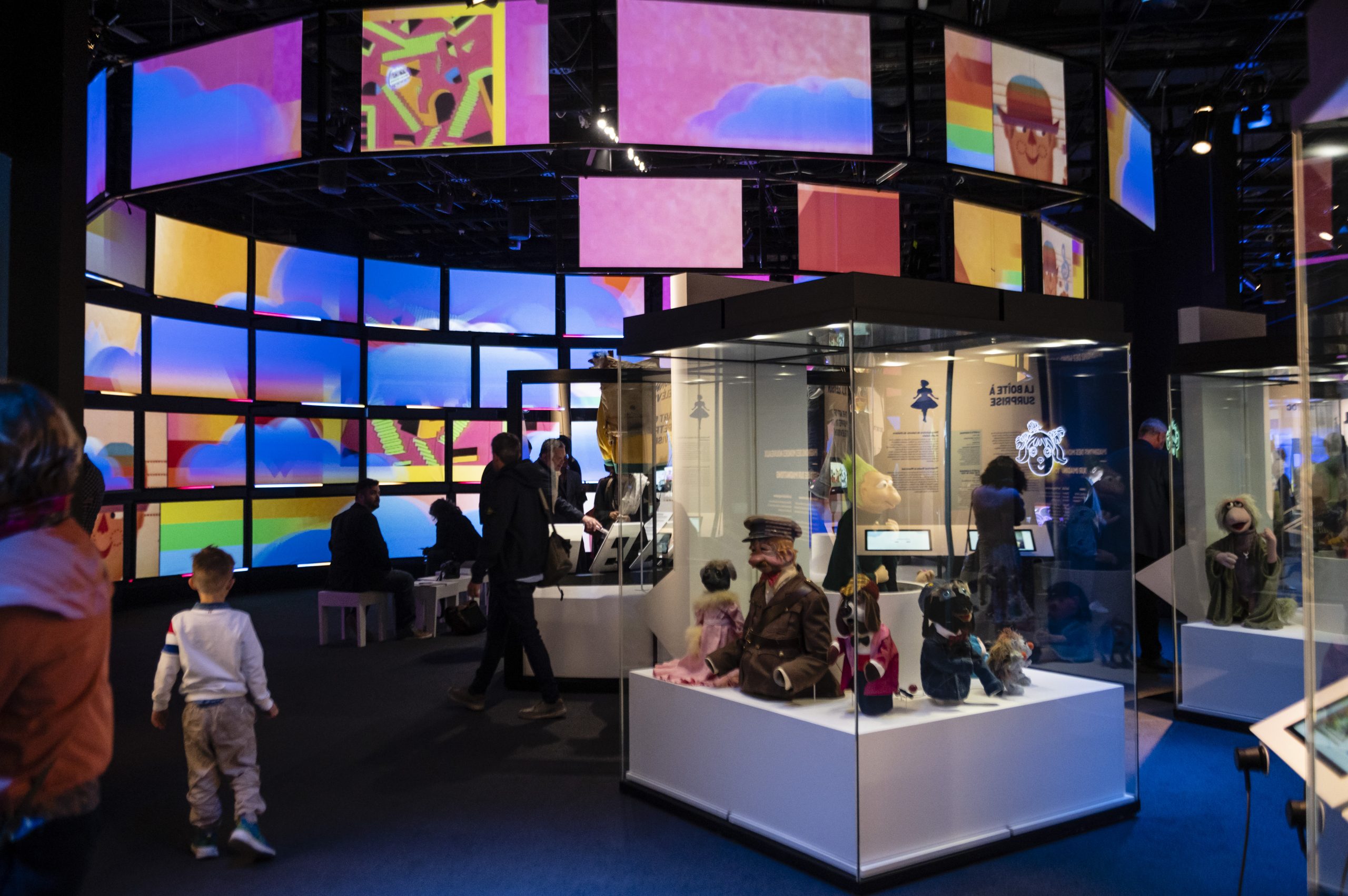 Un groupe de personnes se tient dans le Musée canadien de l'histoire, qui présente des expositions colorées.