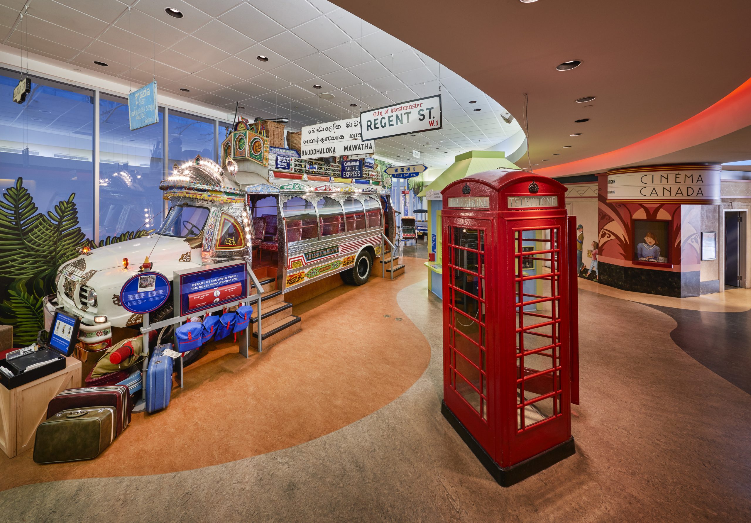 Une salle du Musée canadien de l'histoire avec un autobus rouge et une cabine téléphonique rouge.