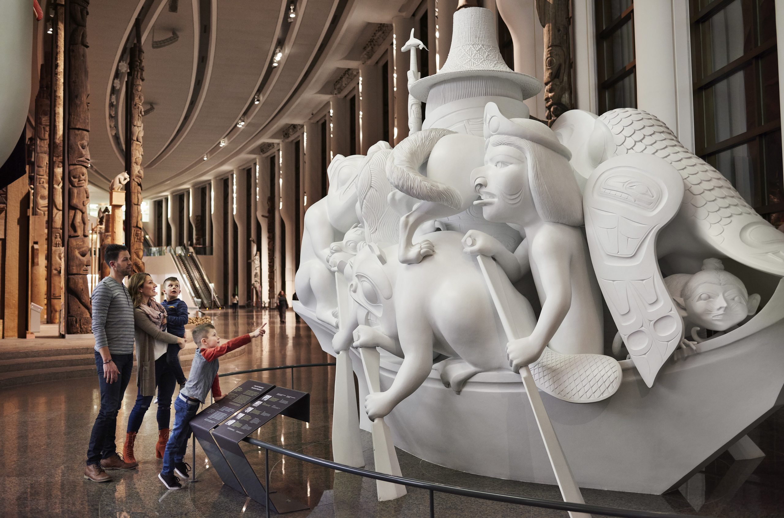 Un groupe de personnes à Ottawa qui visite le Musée canadien de l'histoire, est captivé par une sculpture.