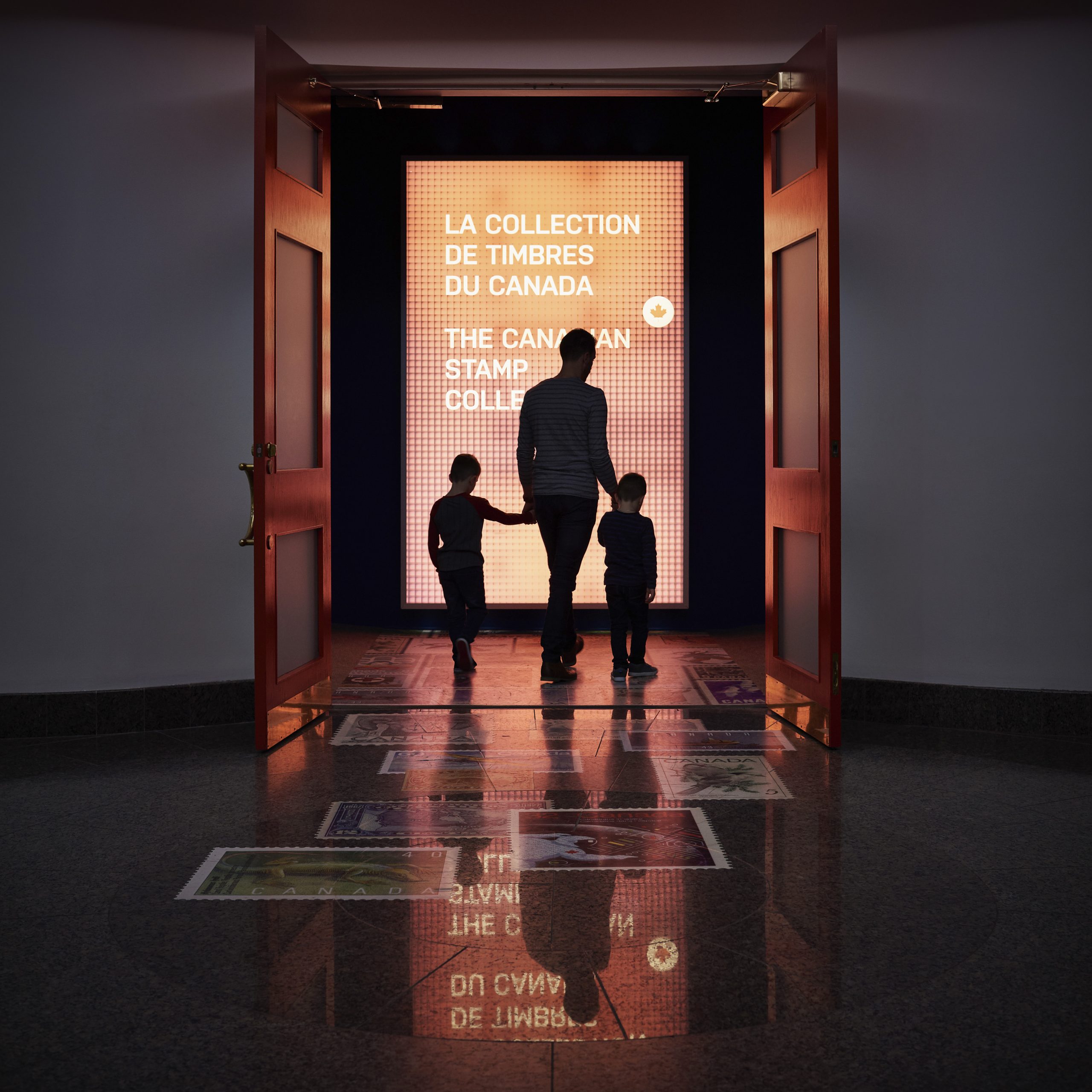 A man and two children walking through an exhibit at the Canadian Museum of History in Ottawa.