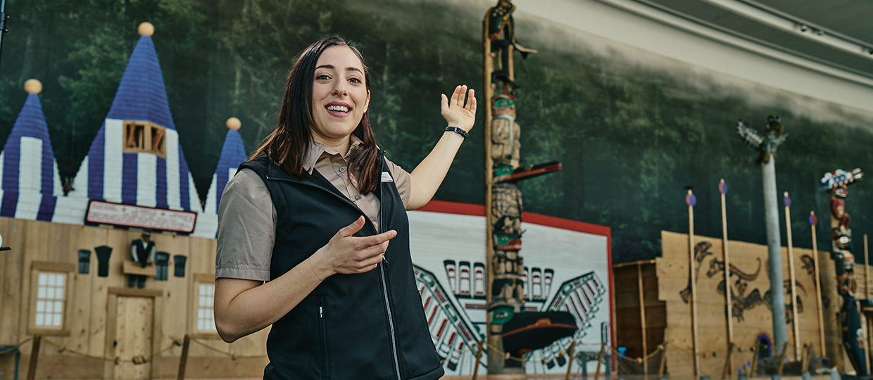 Une femme se tient devant un totem au Musée canadien de l'histoire à Ottawa.