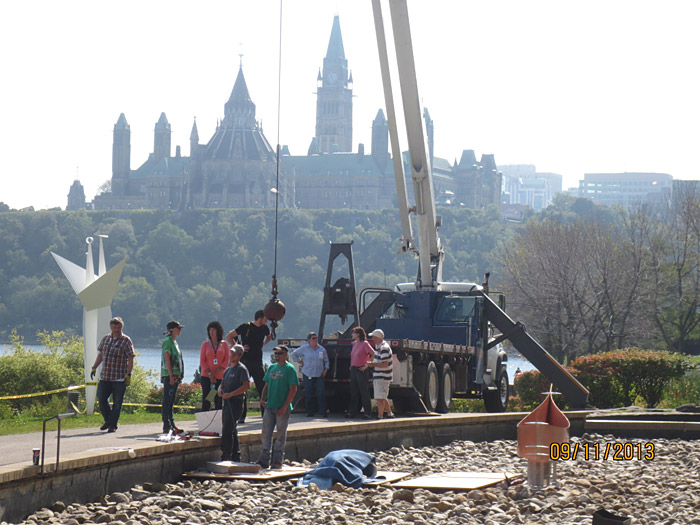 Un groupe de personnes debout à côté d’une grue à Ottawa.