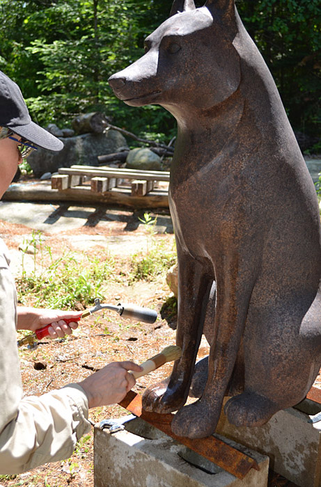 Une femme peignant une statue de loup au Musée canadien de l'histoire à Ottawa.