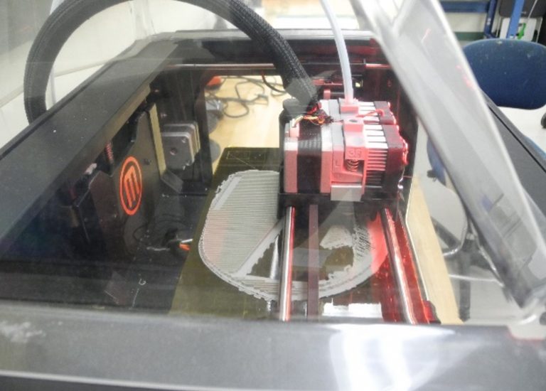 A large 3D printer replicates the skull.