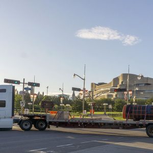 Un camion-remorque transportant le monument passe devant le bâtiment du Musée.