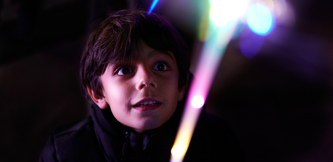 Un garçon regardant les lumières colorées